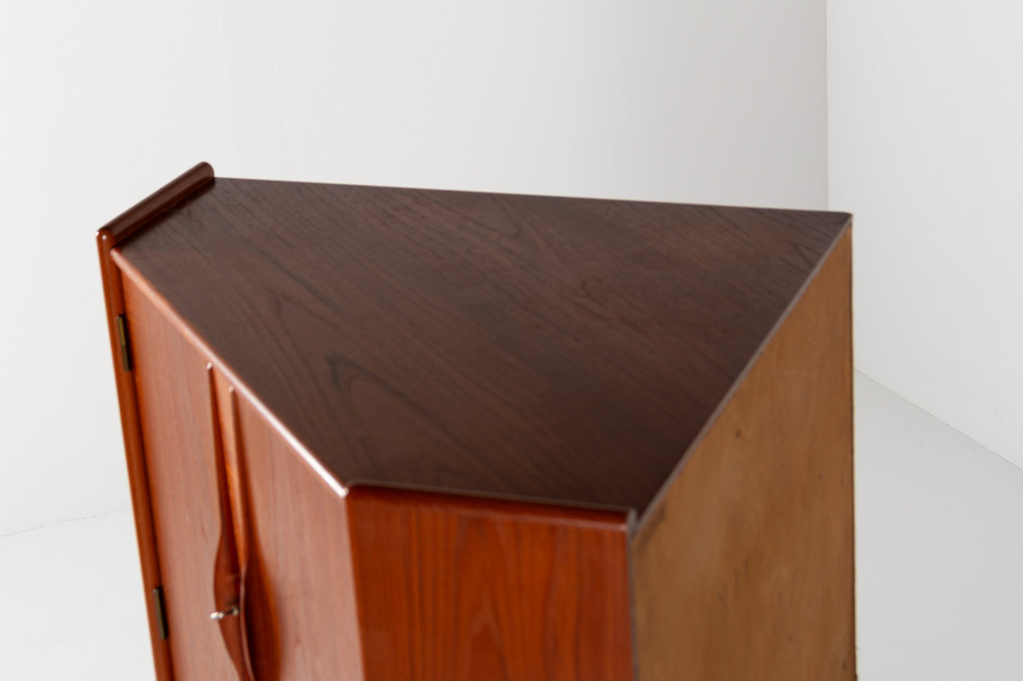 A close-up of a mid-century modern wooden cabinet with a rich dark brown top and warm orange-brown side panels, set against a plain white background.