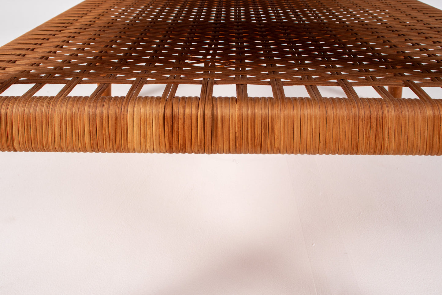 Woven rattan shelf detail under teak coffee table