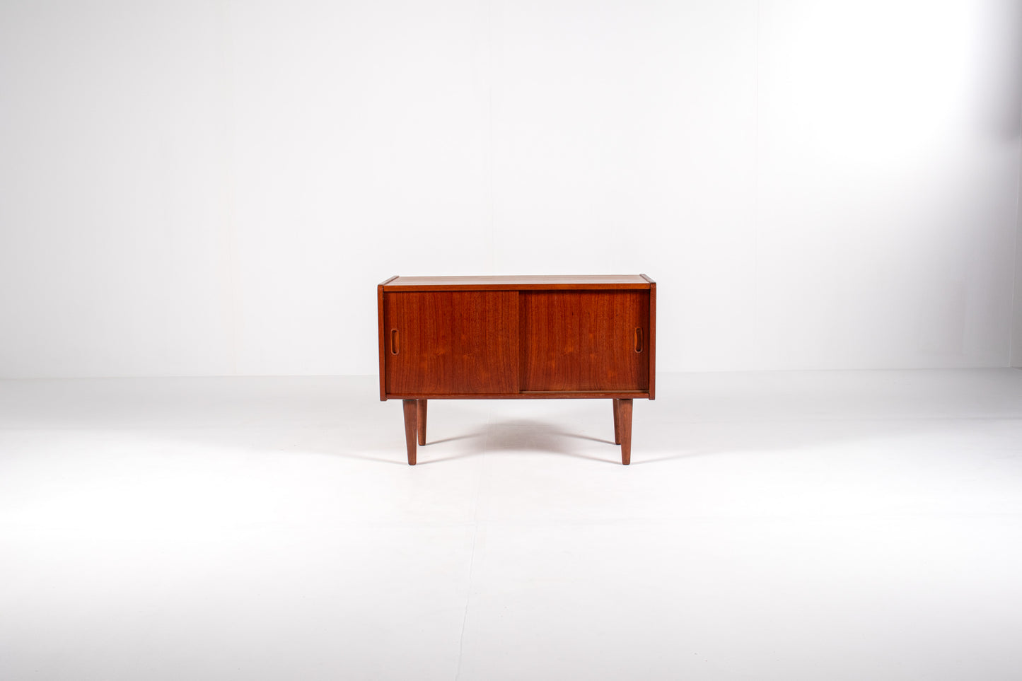 Compact vintage teak cabinet with recessed handles and tapered legs
