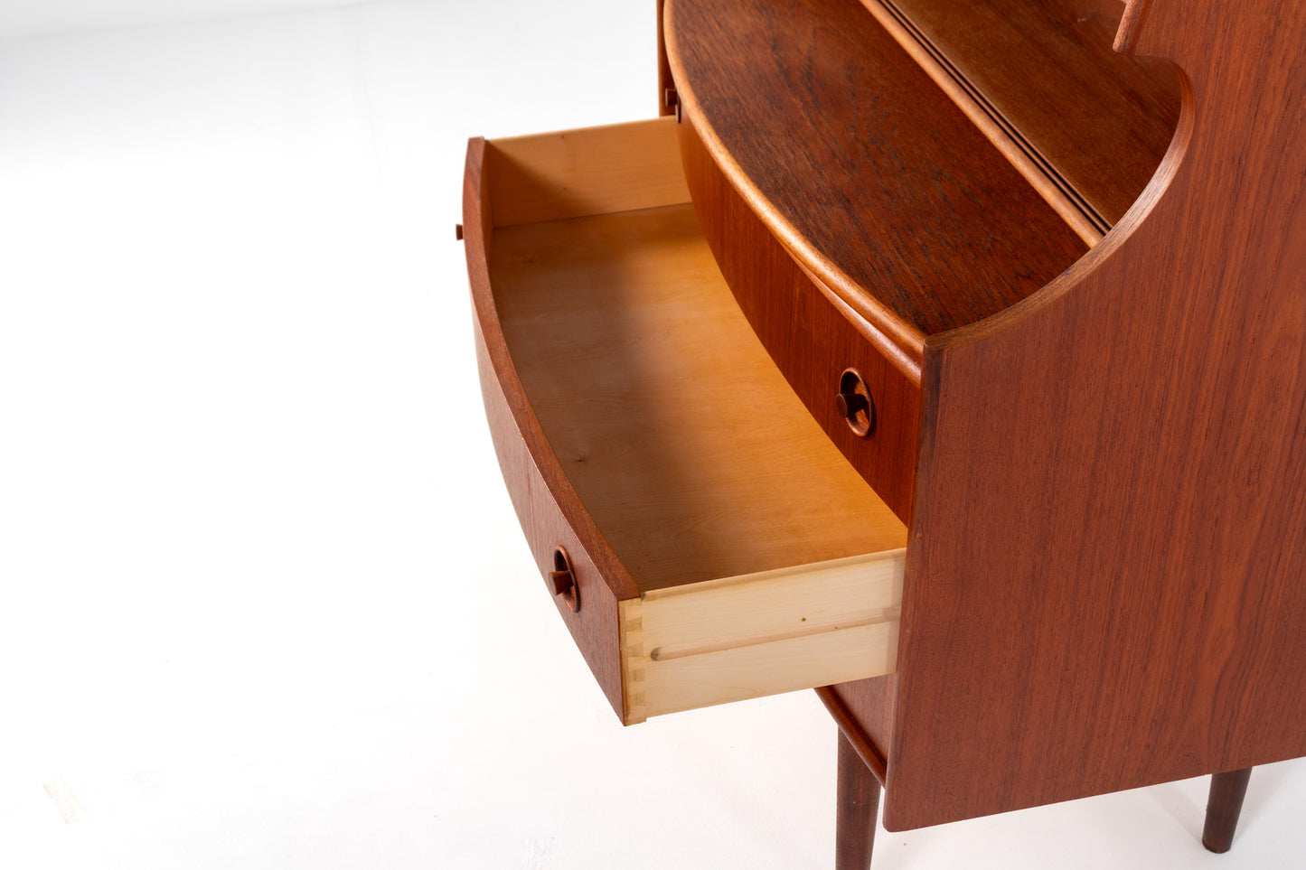 Close-up of a mid-century modern wooden writing desk by Gunnar Falsig for Falsig Møbler with a warm reddish-brown finish and a light natural wood drawer pull, with one drawer pulled open on a white background.