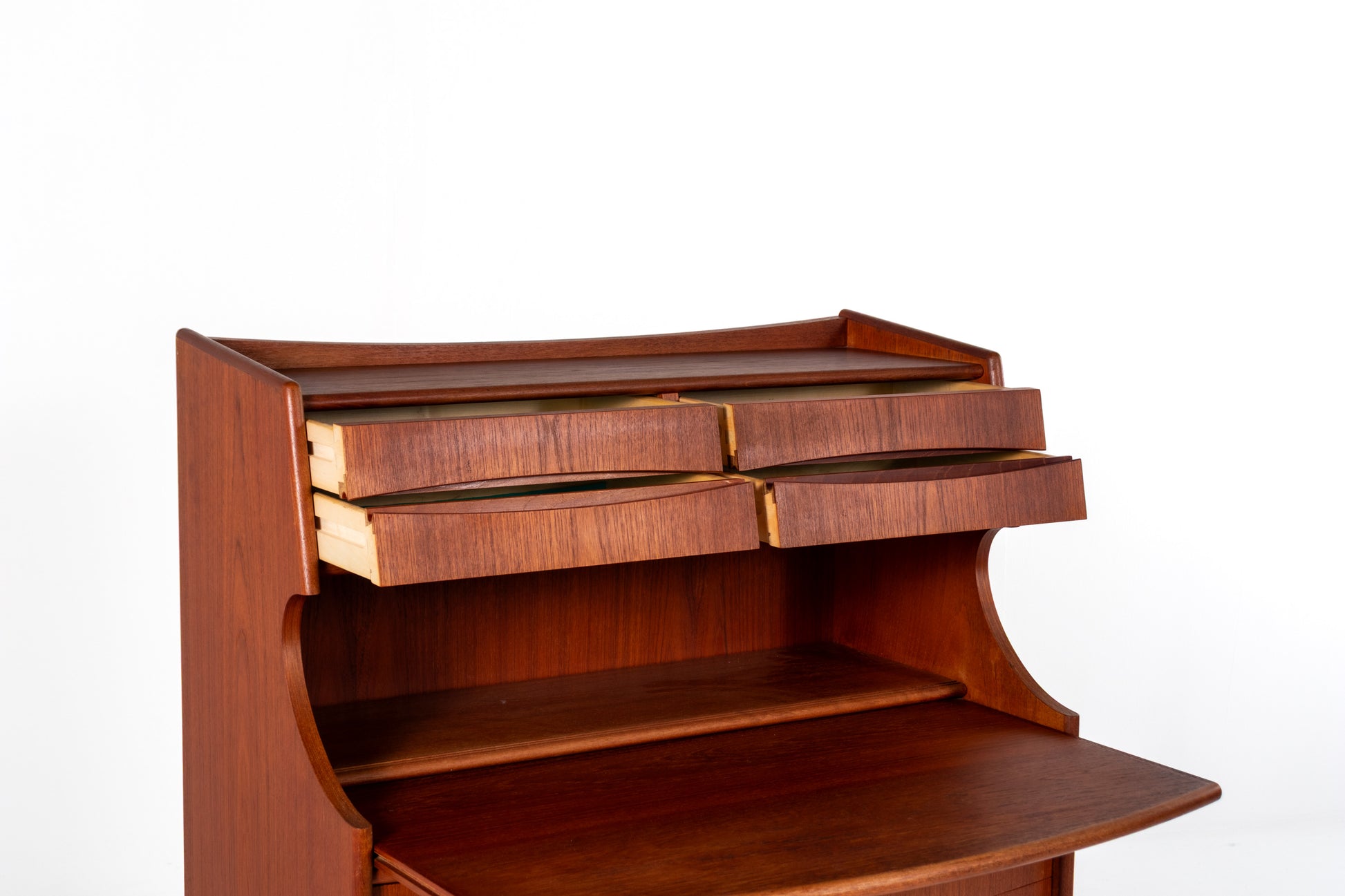 A close-up of a reddish-brown wooden desk or secretary with multiple drawers and a slanted writing surface, photographed against a plain white background.