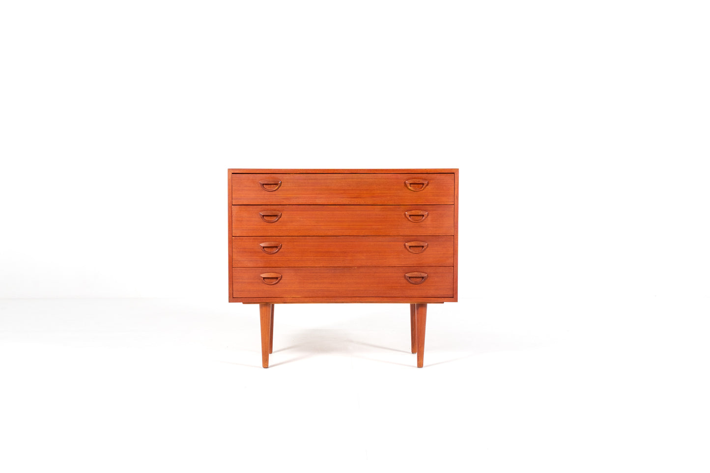 A mid-century modern wooden chest of drawers with five drawers by Kai Kristiansen, shown against a plain white studio background. 