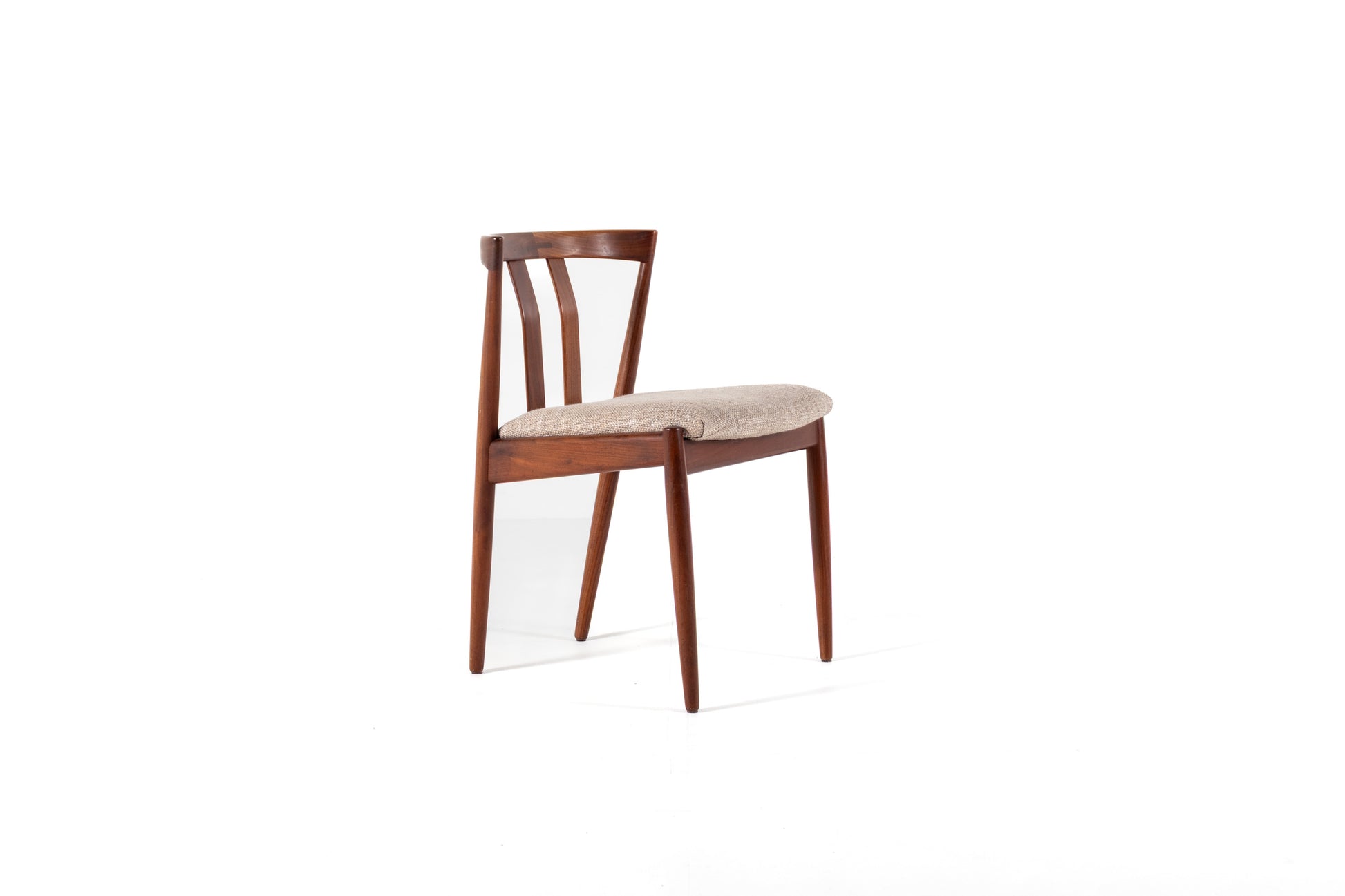 A mid-century modern wooden dining chair with a warm brown frame and a light beige upholstered seat, shown against a plain white background.