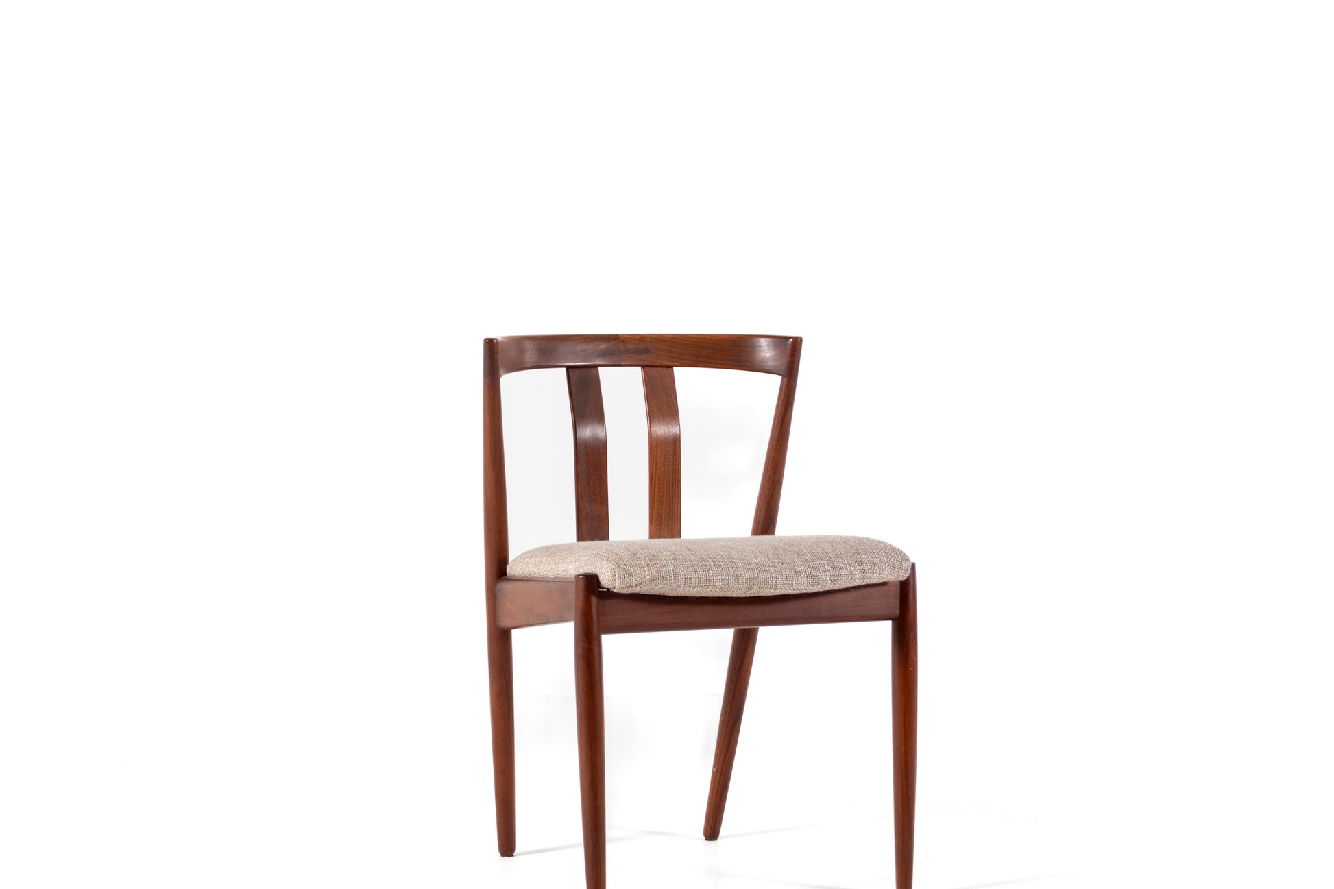 A mid-century modern wooden dining chair with a warm brown wood frame and a light beige textured upholstered seat, shown against a solid white background.