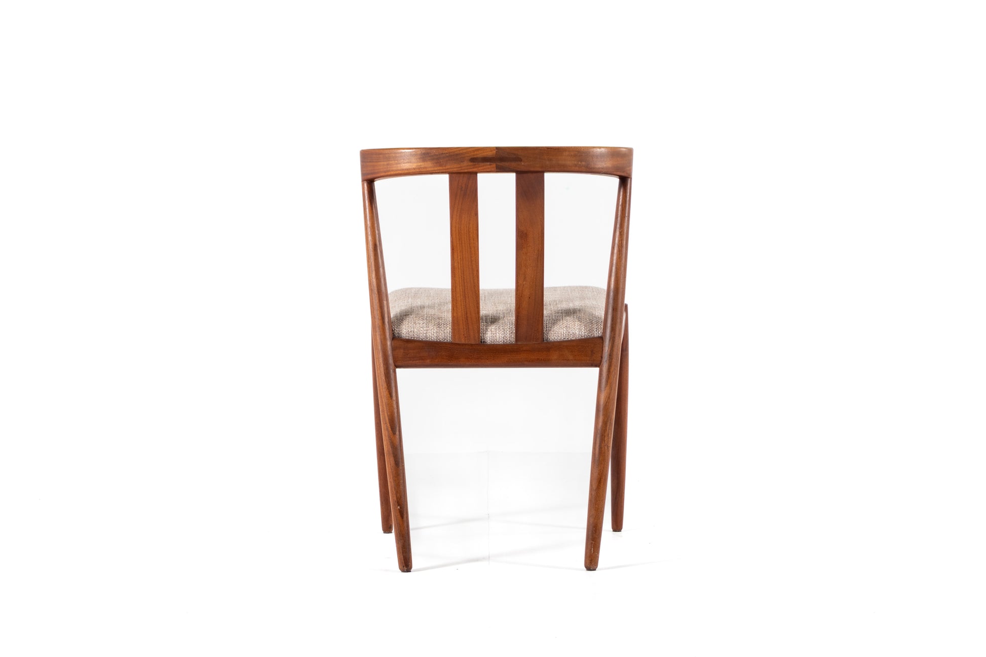 A mid-century modern wooden dining chair with a warm brown teak wood frame, vertical slats, and a textured beige seat cushion, shown from the back against a white background.