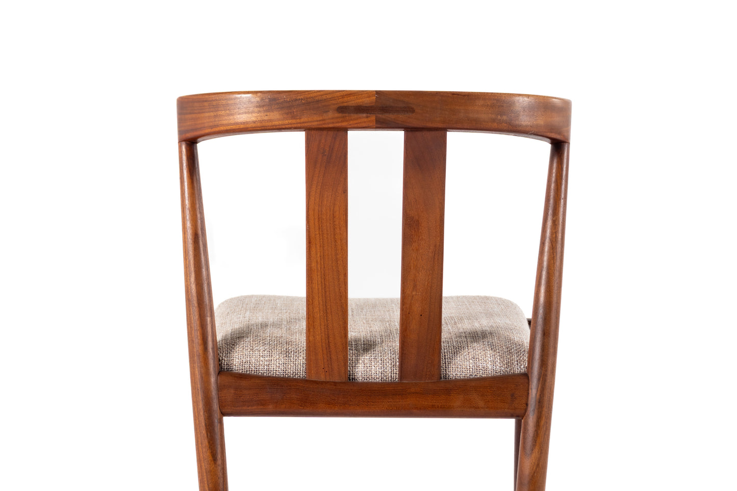 A wooden dining chair viewed from the back, featuring a curved wooden backrest with three vertical spindles and a textured beige fabric seat cushion, isolated on a white background.