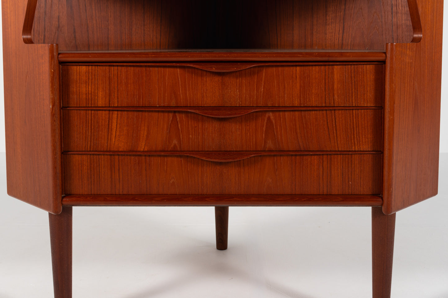 Mid-century modern wooden sideboard or credenza with three drawers, featuring a warm reddish-brown wood finish and tapered legs.