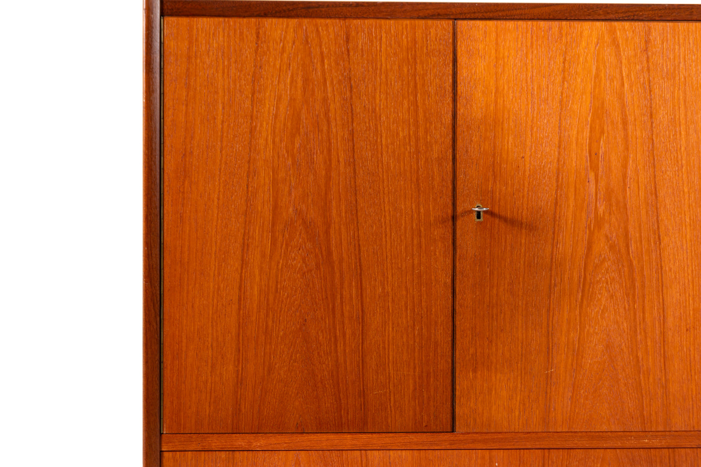 A mid-century modern wooden cabinet with a warm reddish-brown finish, featuring two upper doors and a lower drawer