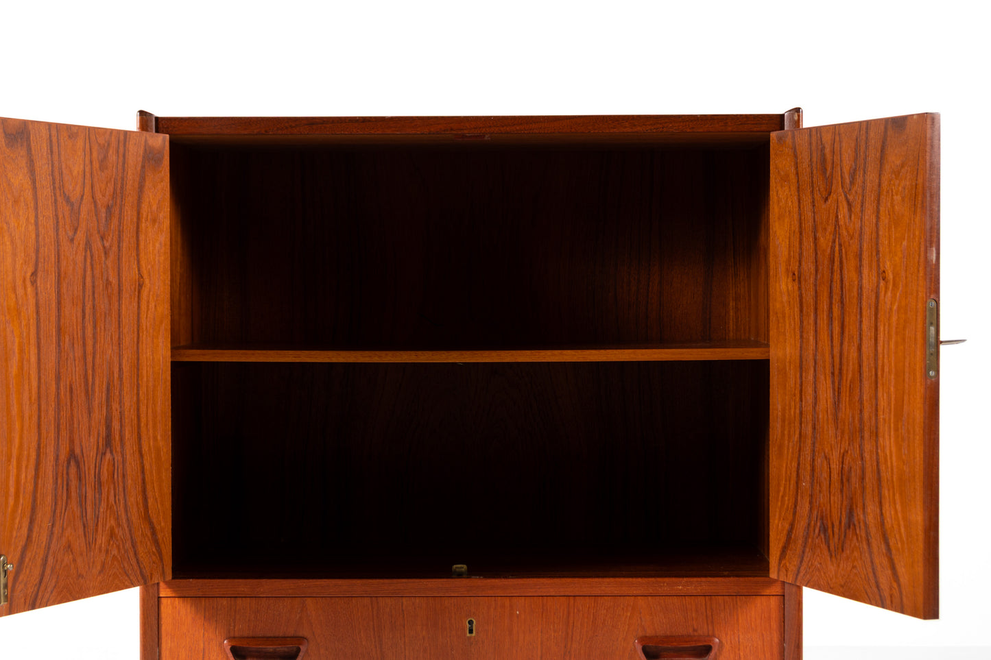A mid-century modern wooden cabinet with a warm reddish-brown finish, featuring two upper doors and a lower drawer