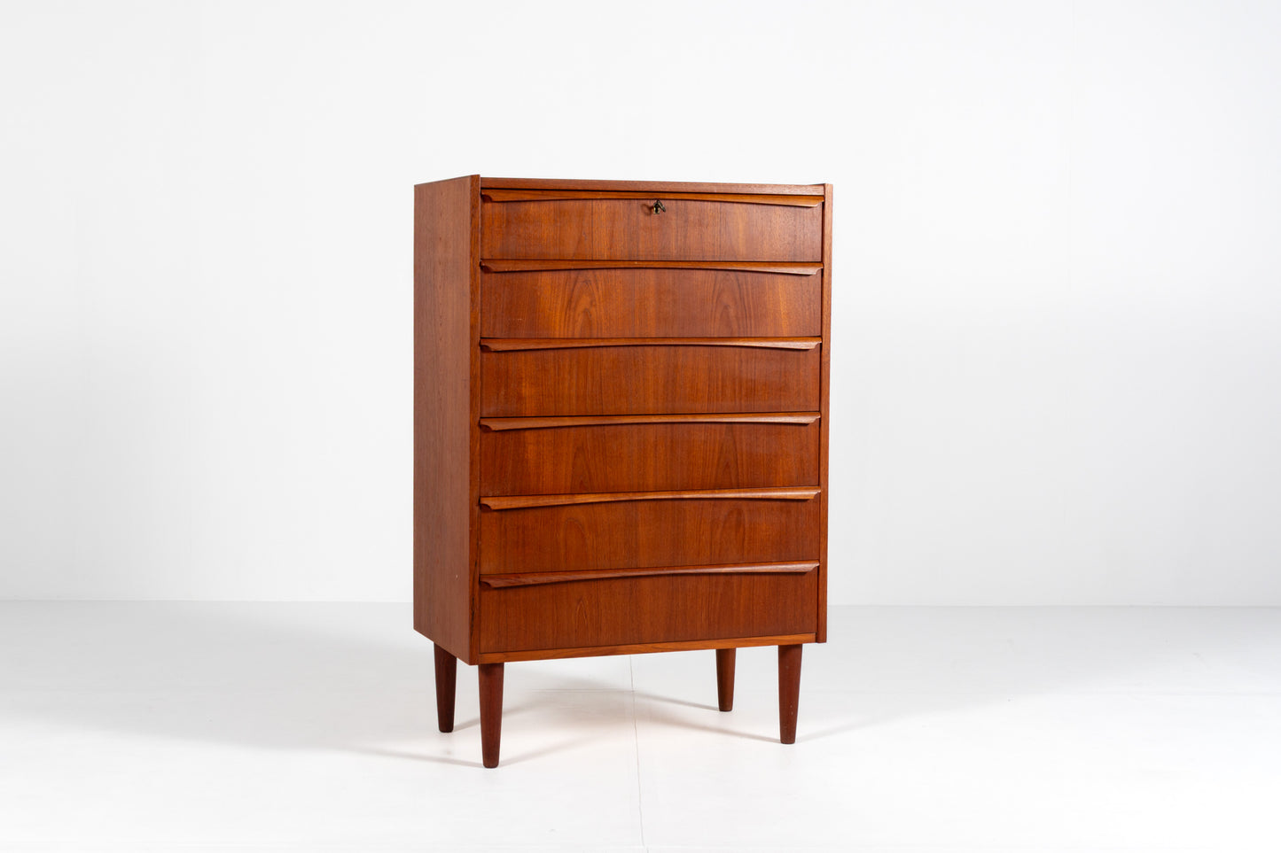 Danish Mid-Century teak tallboy chest of drawers, front view.