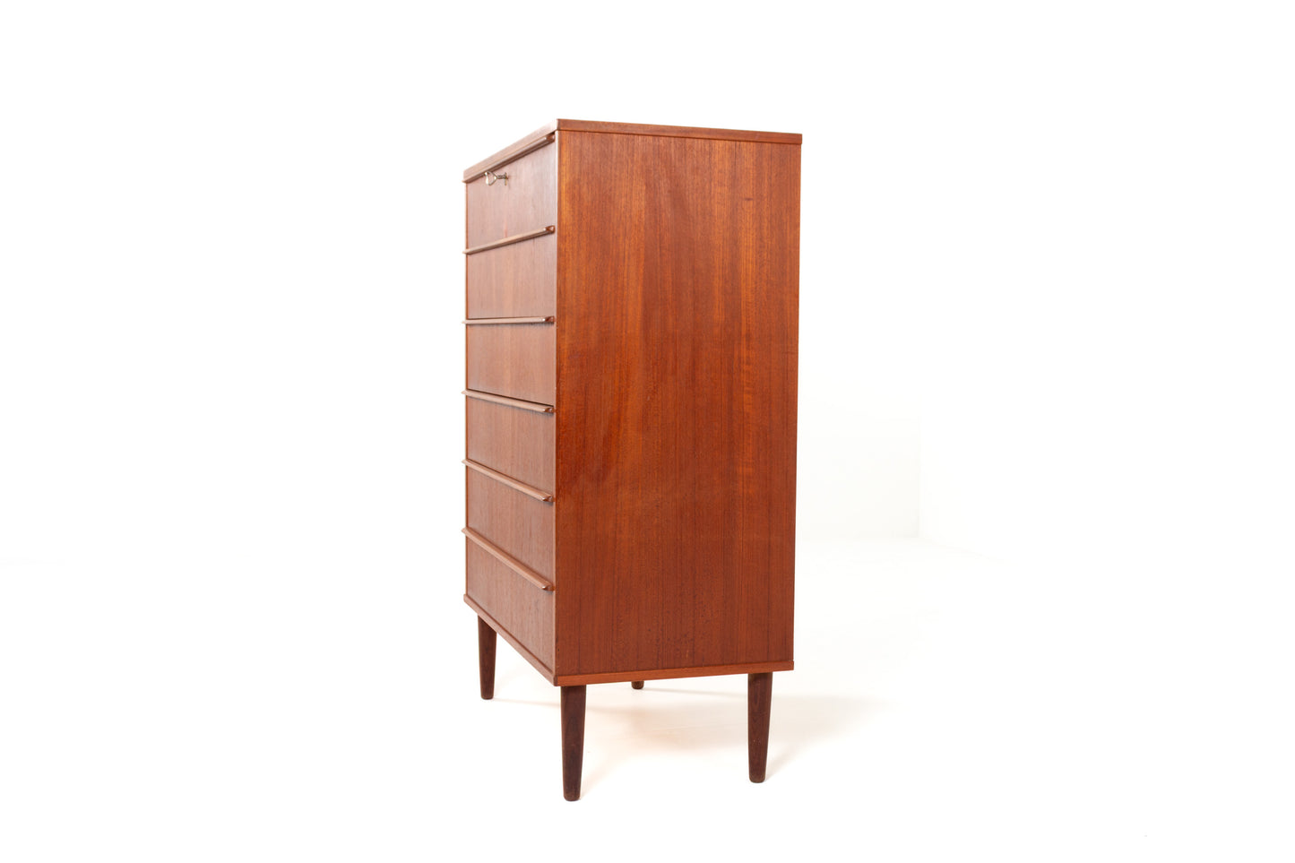 Side view of Danish teak tallboy on tapered legs.