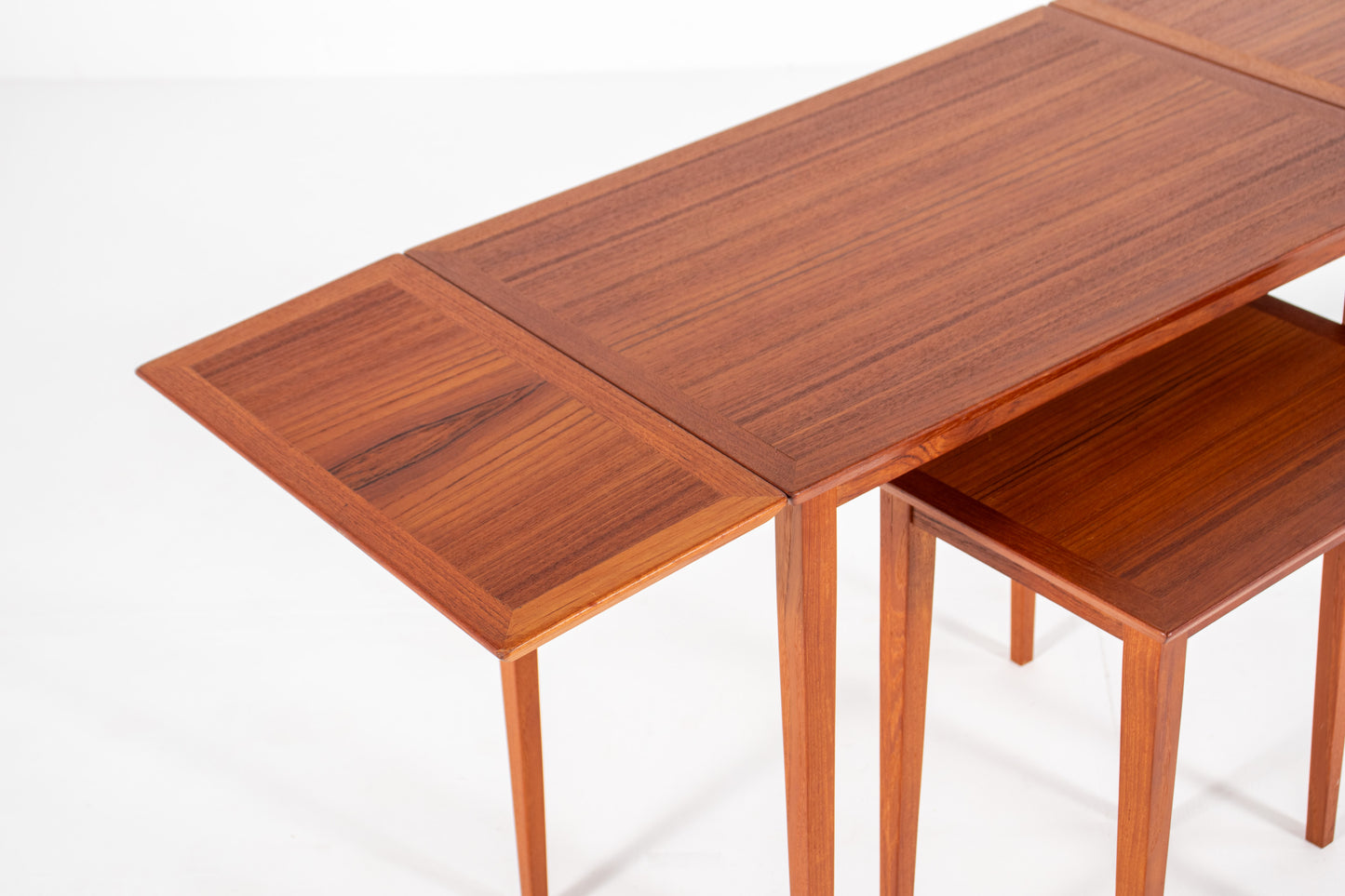 Vintage Danish nesting table with both drop leaves fully extended, demonstrating the versatile space-saving design.