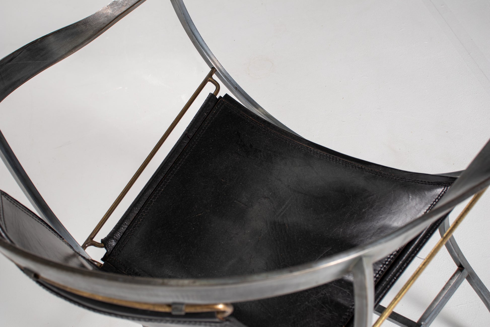 A close-up of A mid-century modern metal Armchair Alberto Orlandi Pompei  in Steel, Bronze and Black Leather, back view