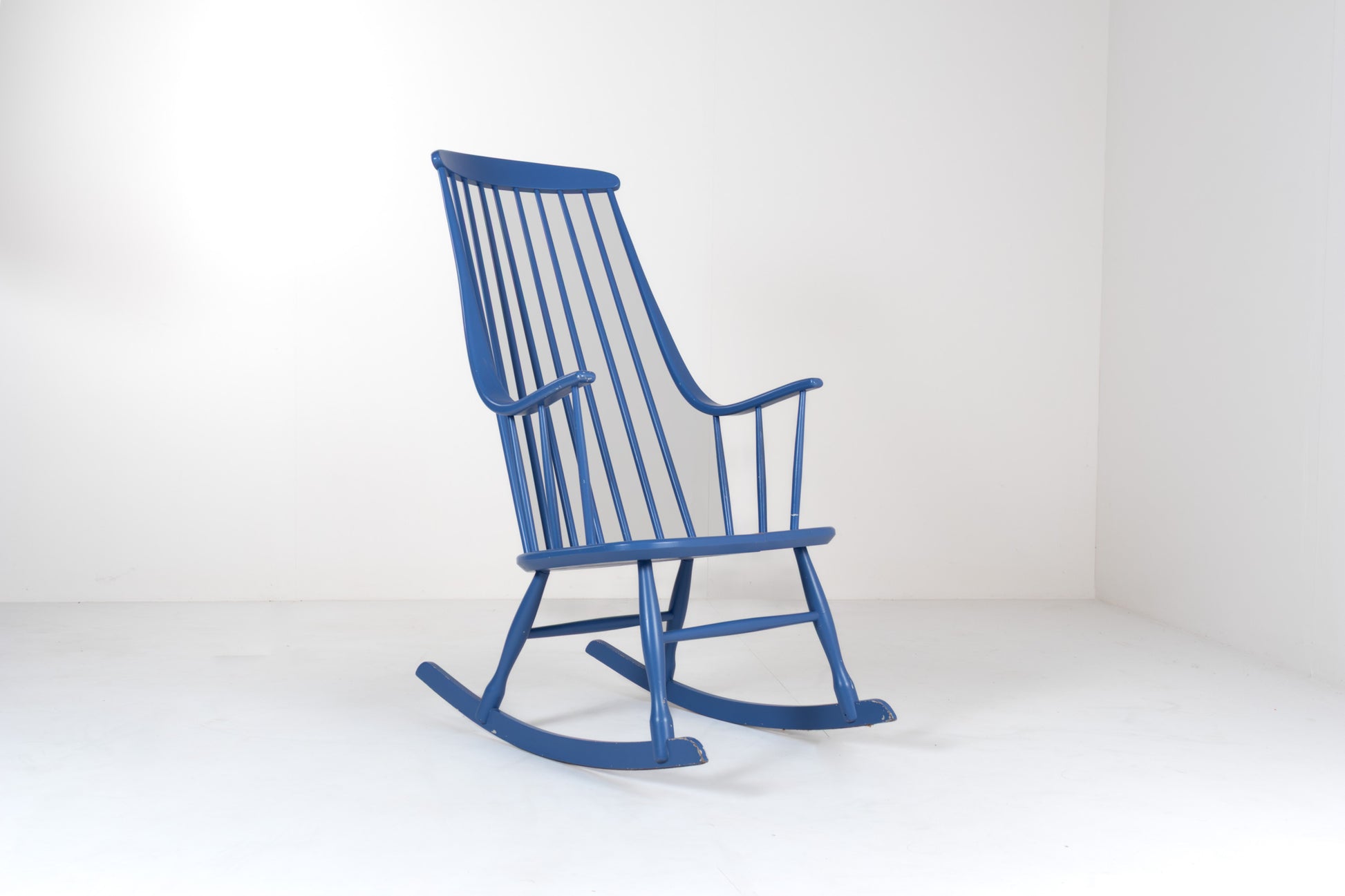 Front view of a vintage 1960s Grandessa rocking chair by Lena Larsson for Nesto in blue painted wood with a tall Windsor-style spindle back and curved armrests.
