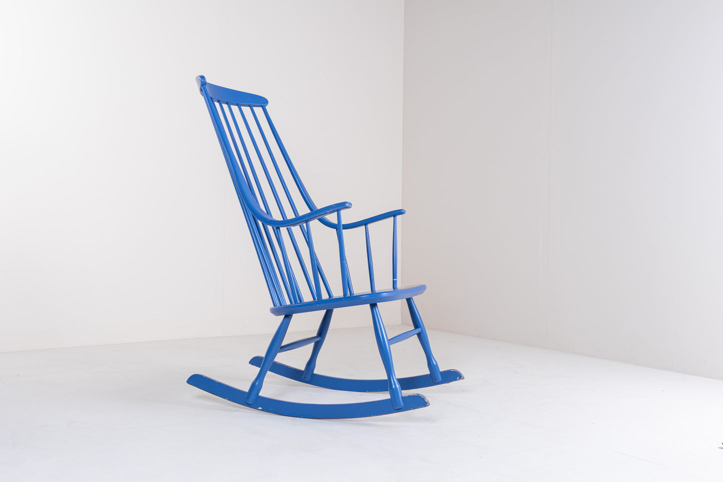 Side profile of a Scandinavian vintage Grandessa rocking chair by Lena Larsson, showing the elegant rocking base, high backrest, and tapered wooden frame.