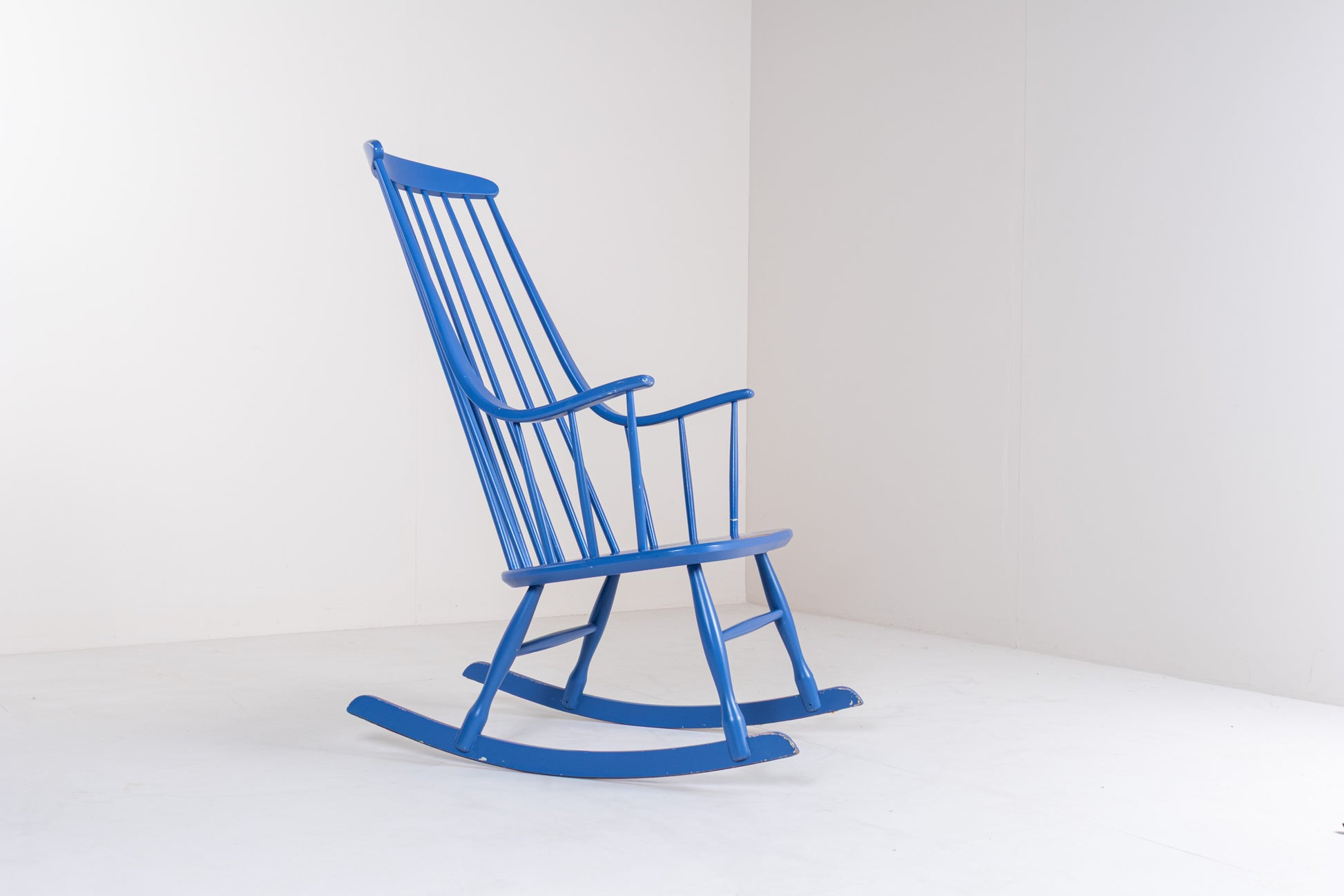 Side profile of a Scandinavian vintage Grandessa rocking chair by Lena Larsson, showing the elegant rocking base, high backrest, and tapered wooden frame.