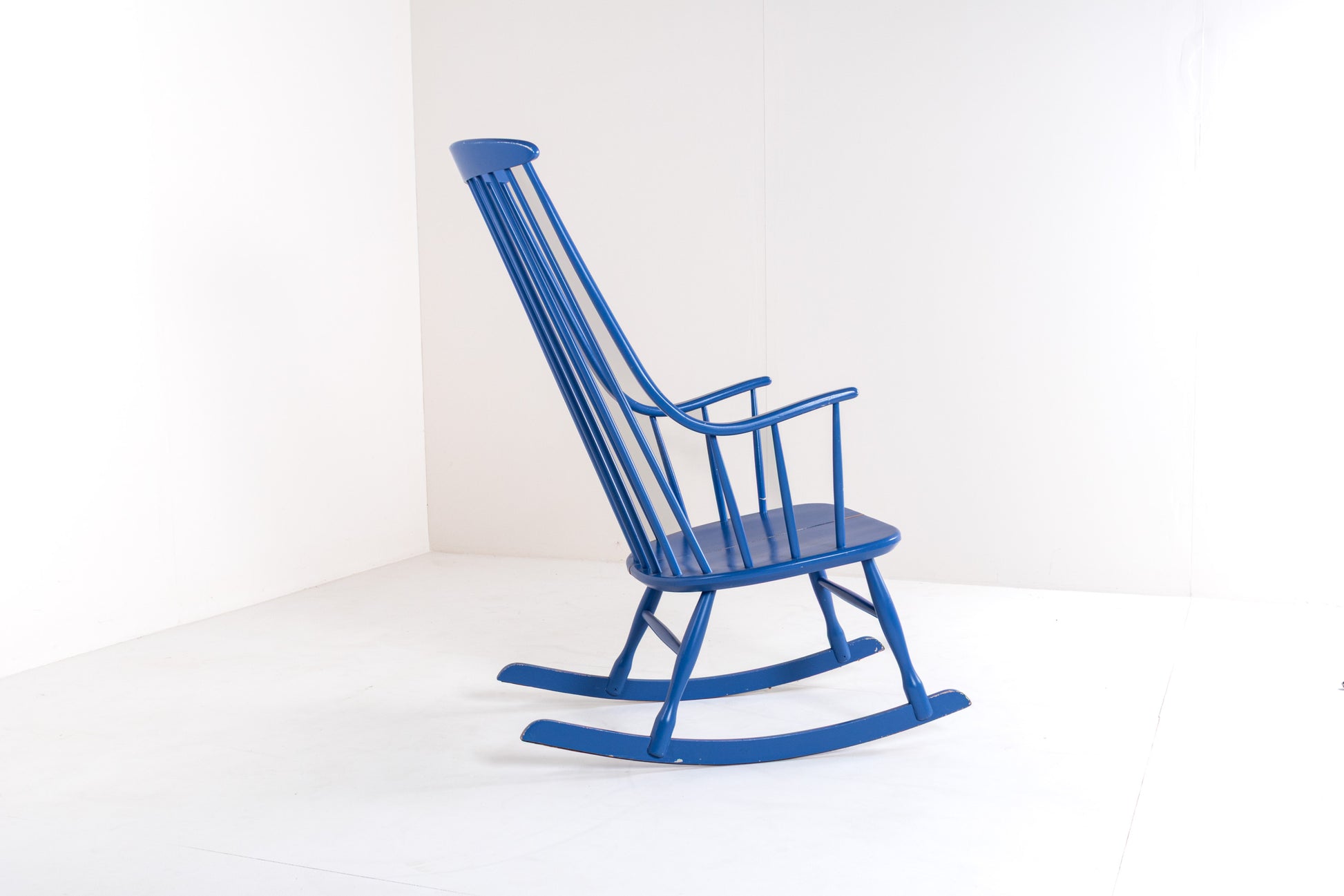 Side profile of a Scandinavian vintage Grandessa rocking chair by Lena Larsson, showing the elegant rocking base, high backrest, and tapered wooden frame.
