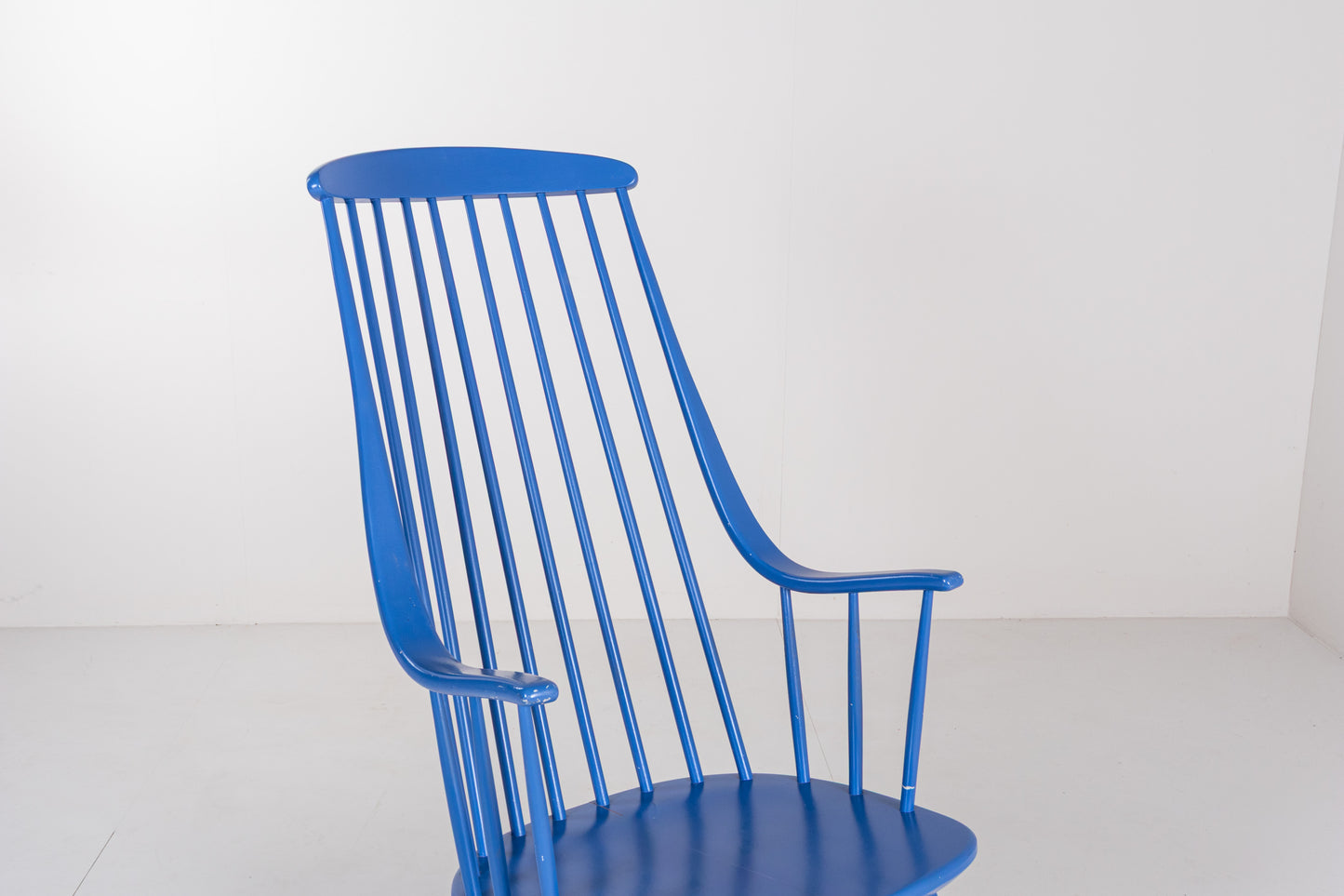 Close-up of the tall spindle backrest and curved top rail of a vintage Grandessa rocking chair by Lena Larsson.