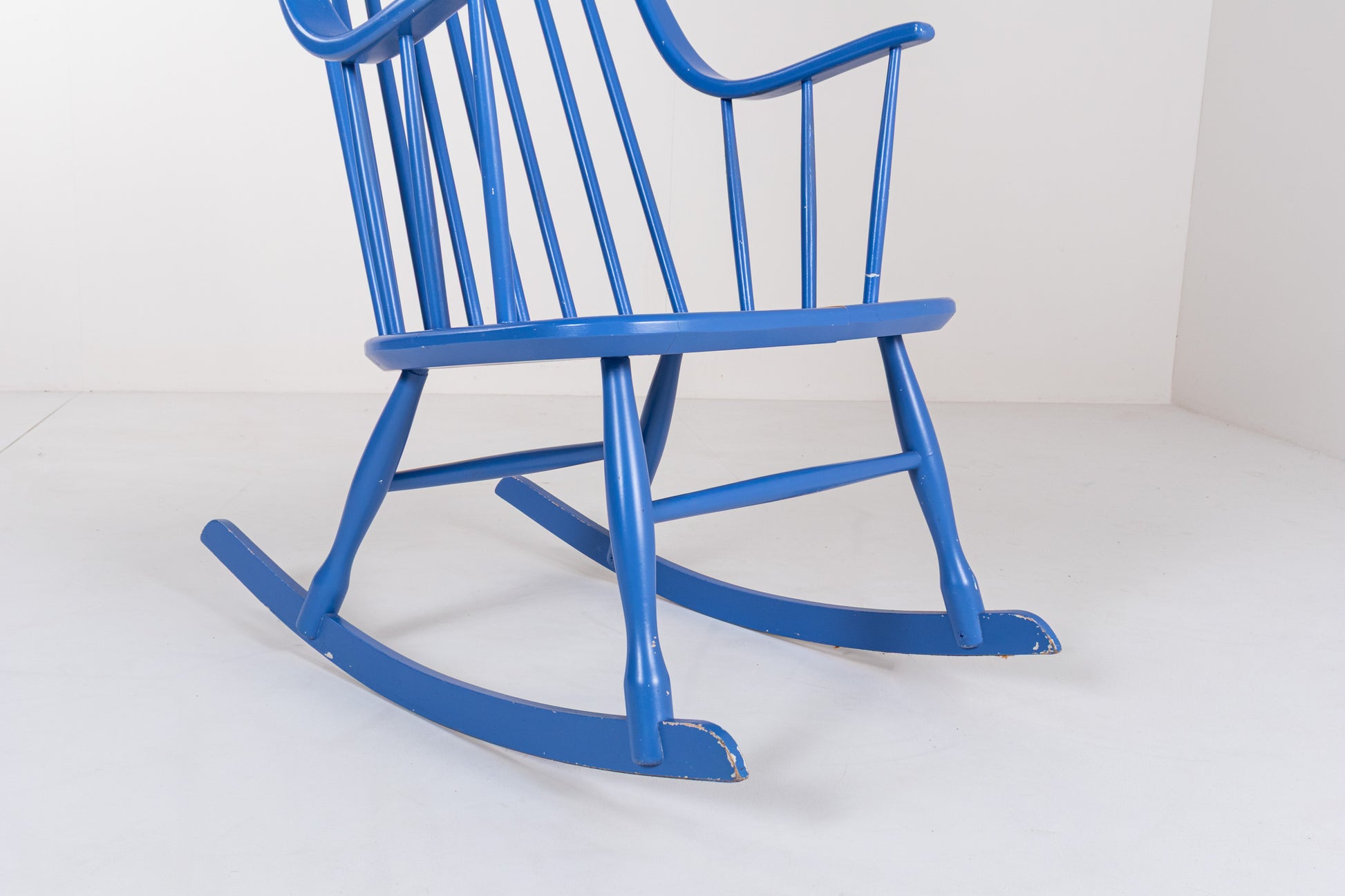 Detail of the curved wooden rockers and tapered legs of a vintage Swedish Grandessa rocking chair.