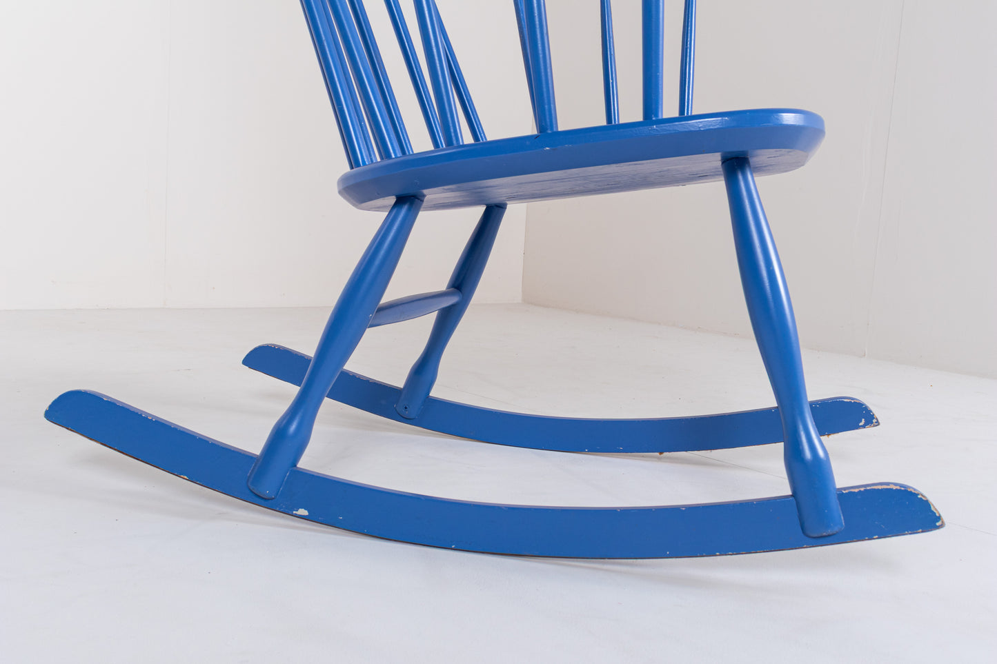 Detail of the curved wooden rockers and tapered legs of a vintage Swedish Grandessa rocking chair.
