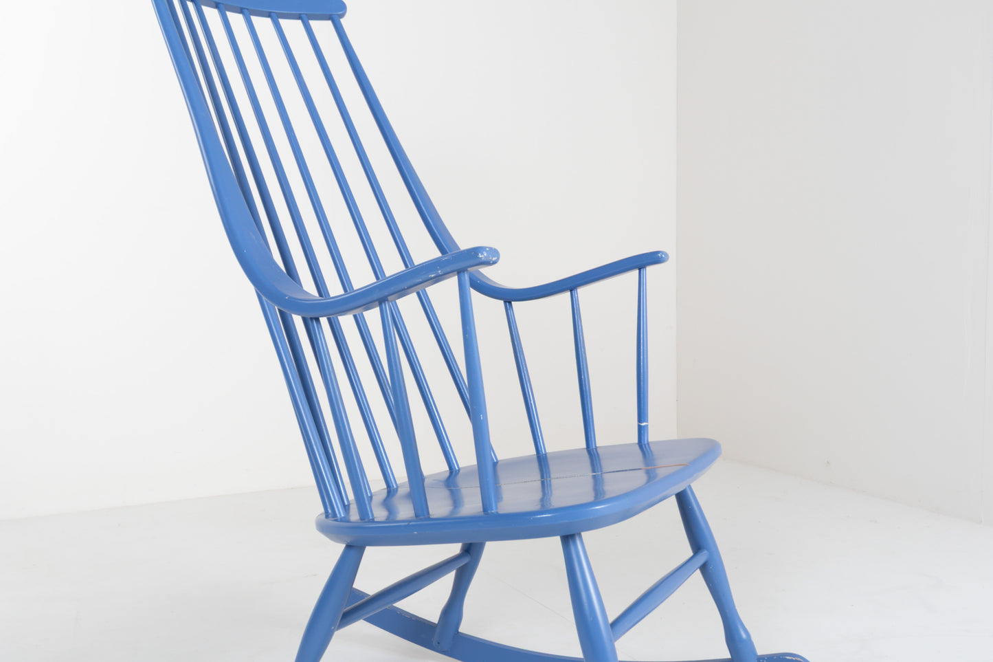 Front view of a vintage 1960s Grandessa rocking chair by Lena Larsson for Nesto in blue painted wood with a tall Windsor-style spindle back and curved armrests.