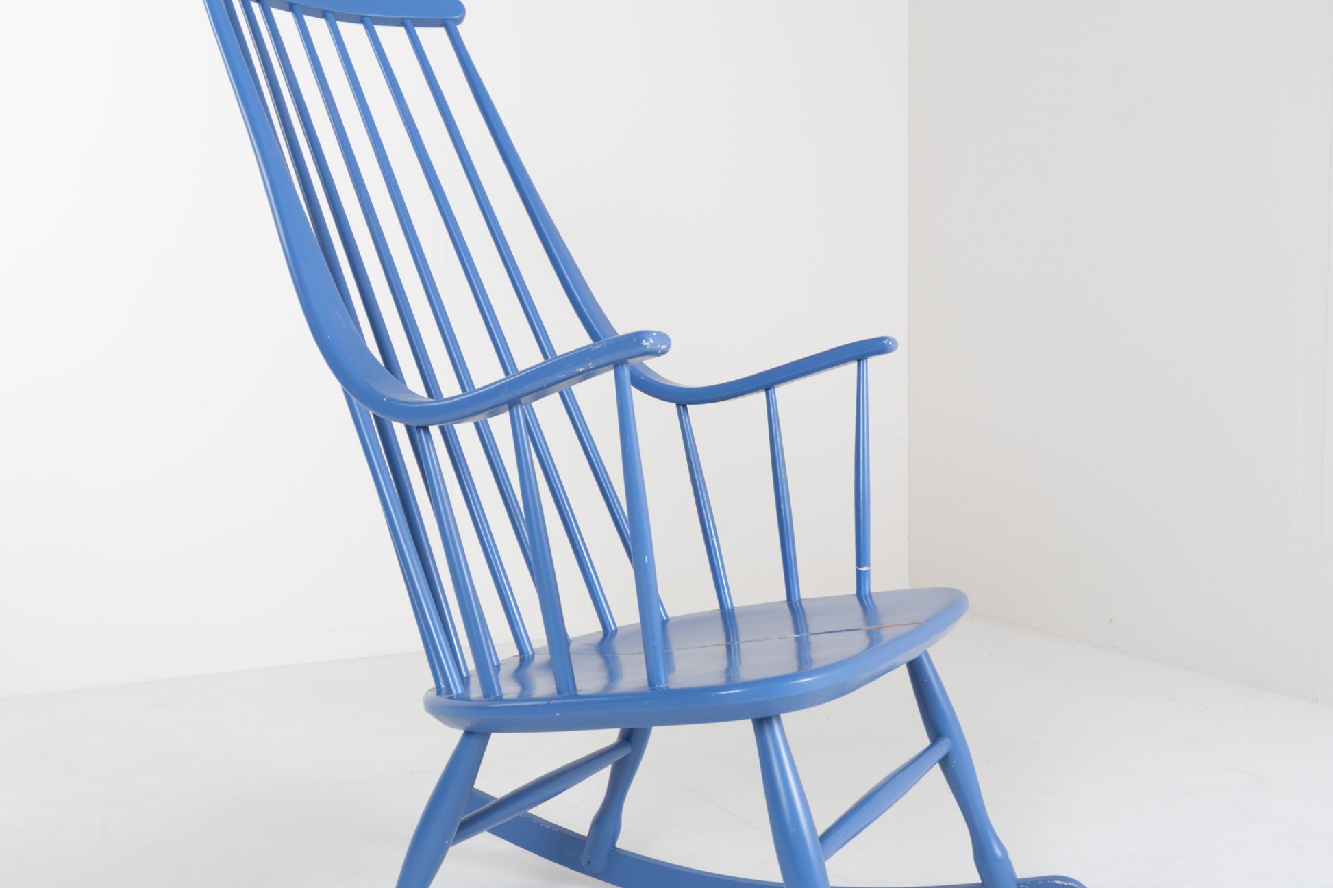 Front view of a vintage 1960s Grandessa rocking chair by Lena Larsson for Nesto in blue painted wood with a tall Windsor-style spindle back and curved armrests.