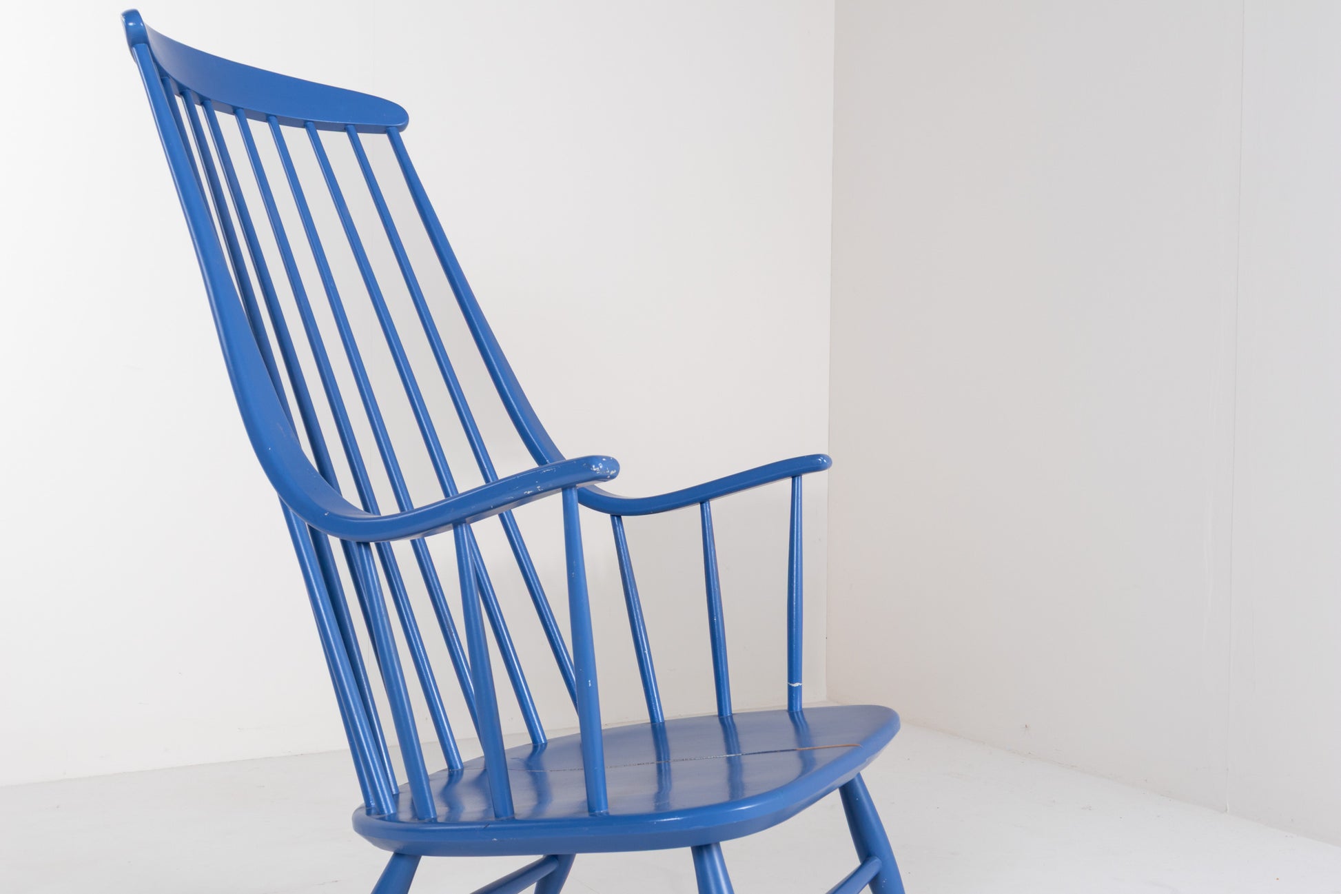 Close-up of the tall spindle backrest and curved top rail of a vintage Grandessa rocking chair by Lena Larsson.