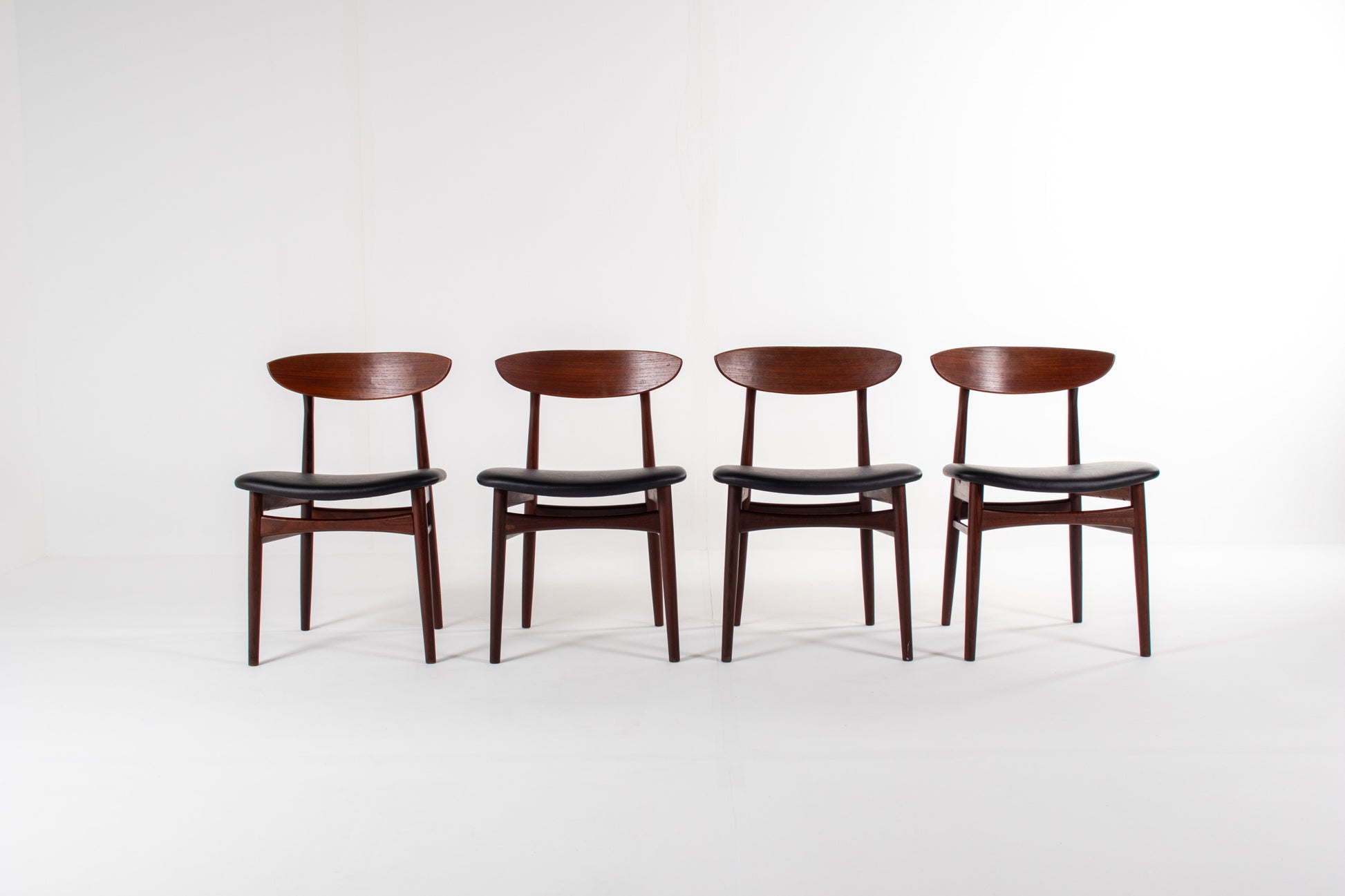 Set of four Danish mid-century modern teak dining chairs with black skai seats
