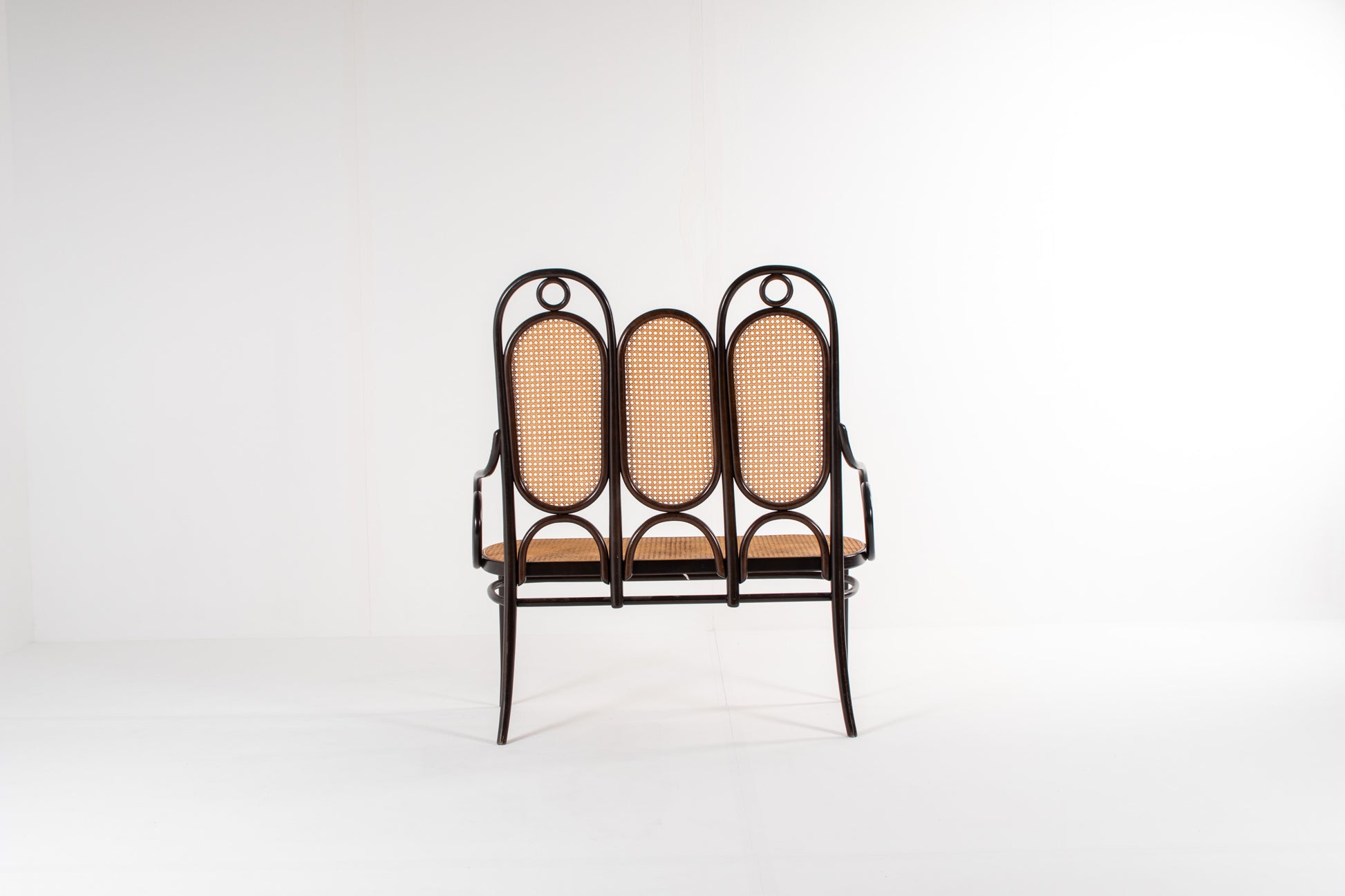 Bentwood bench with scroll arms and decorative rings, Thonet
