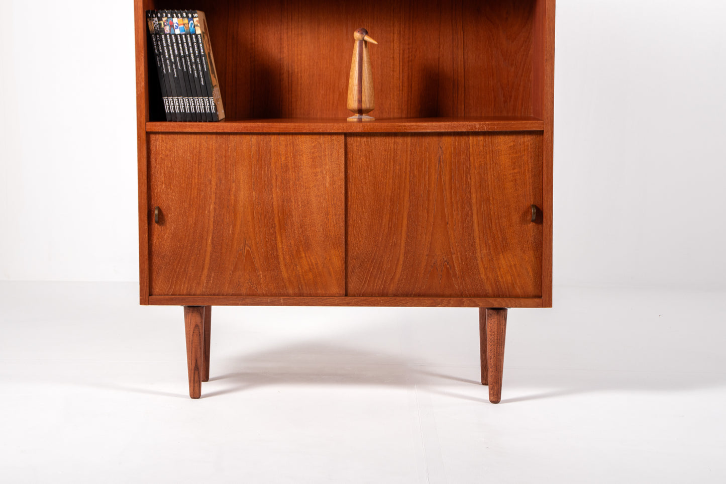 Close-up of lower sliding teak doors and grain detail on Danish mid-century bookcase