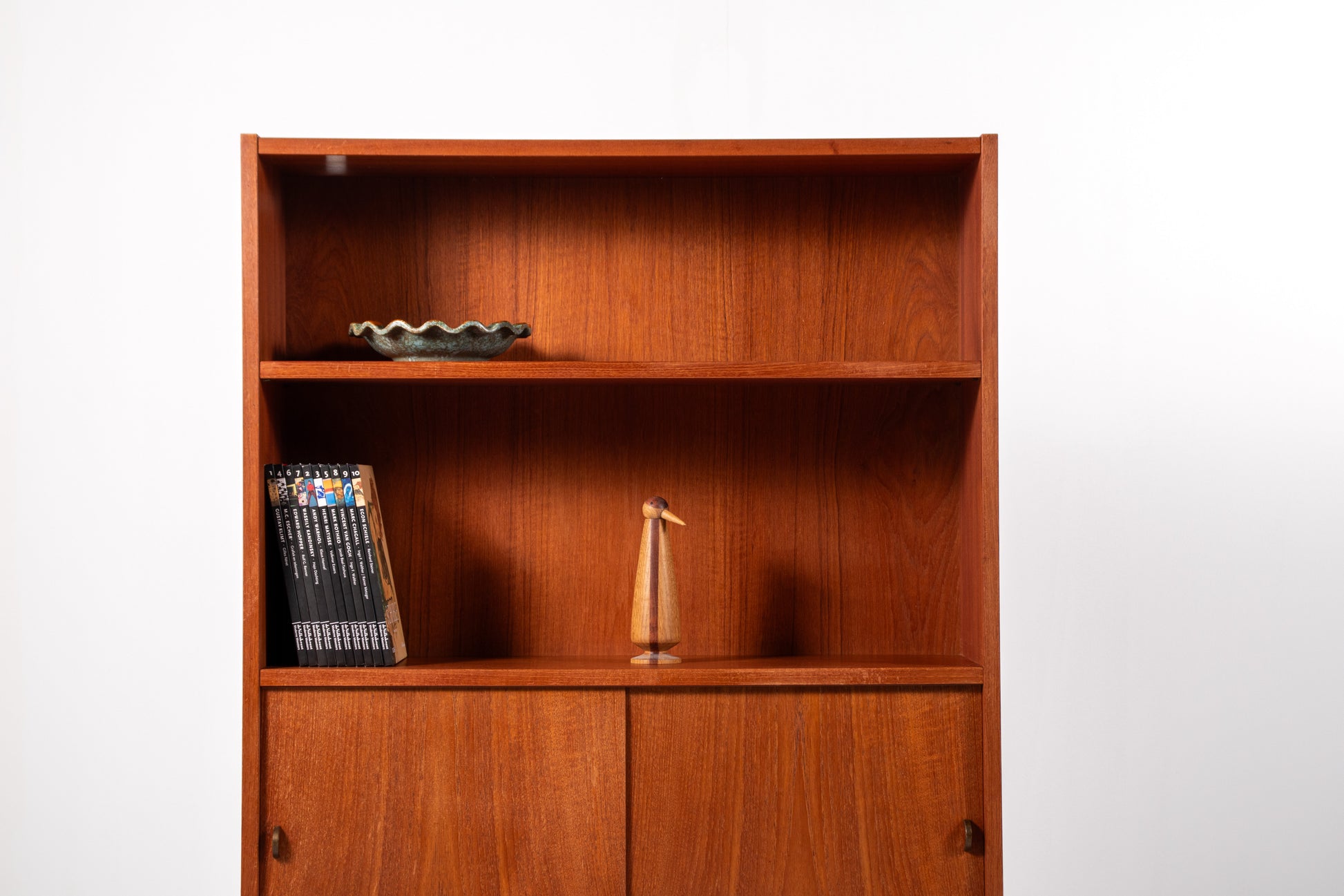 Interior view showing cabinet storage and adjustable shelf behind sliding doors, teak bookcase