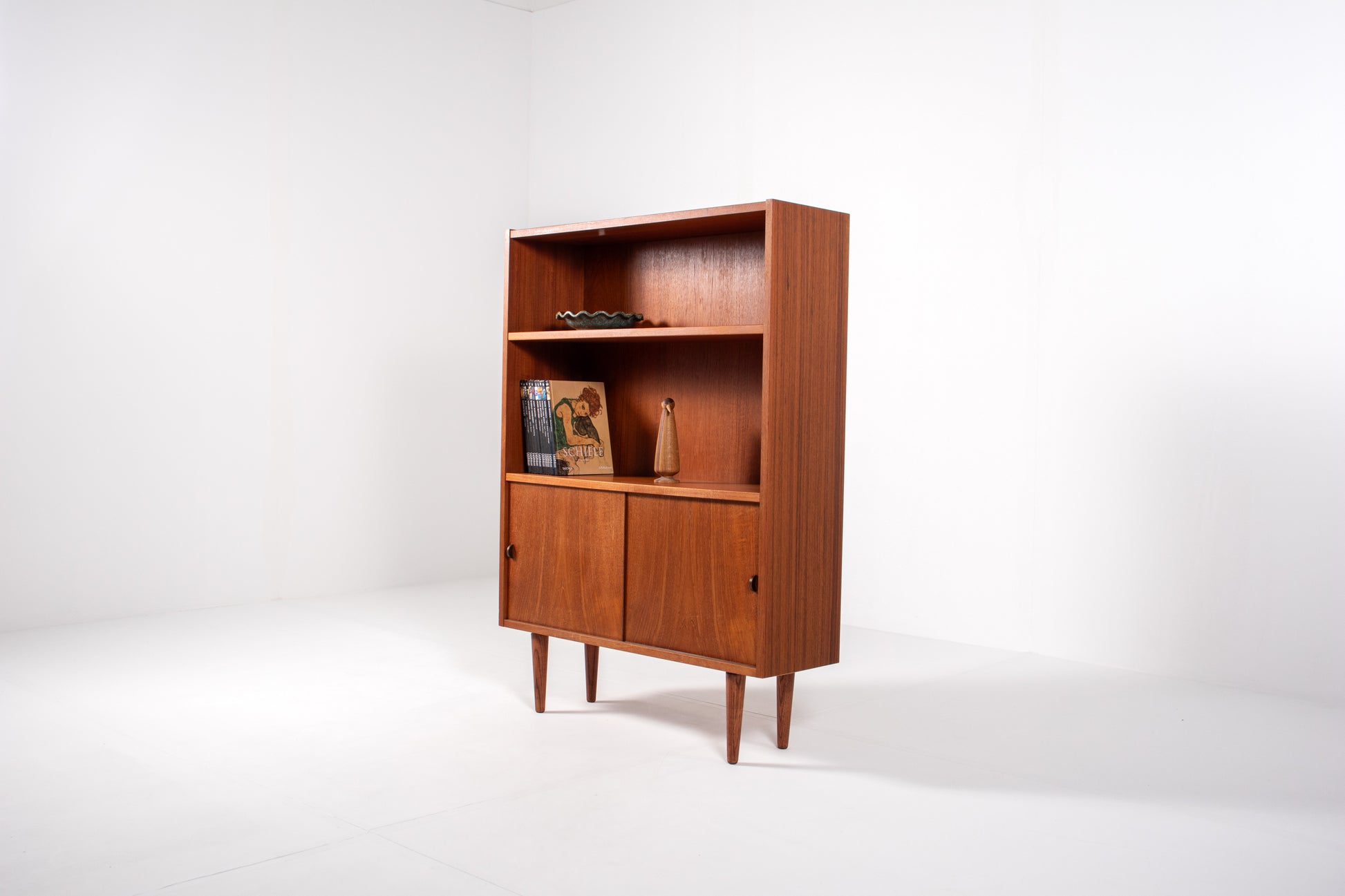 Angled view of Danish teak bookcase on tapered legs, Sejling Skabe N.P. Nielsen
